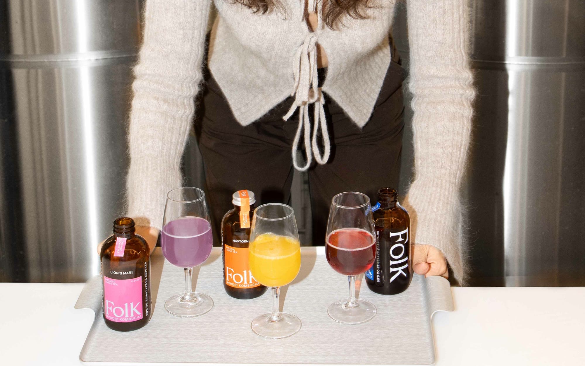 A tasting in the brewery: Folk Kombucha bottles and glasses of three flavours on a tray